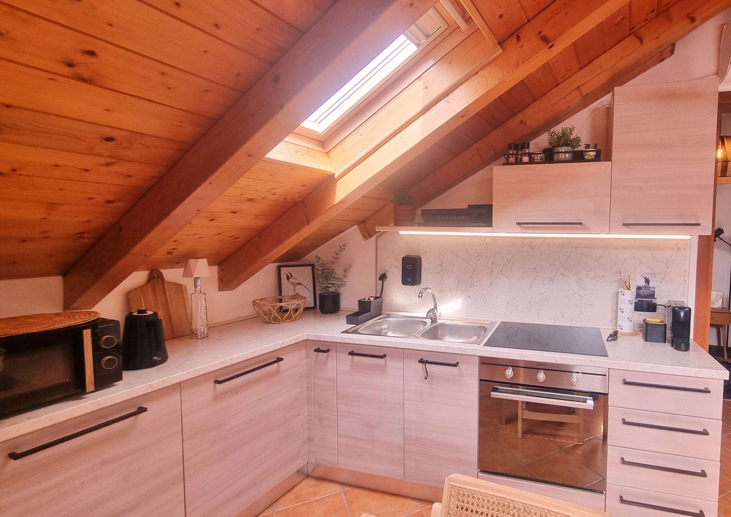 Cuisine moderne sous combles avec poutres en bois