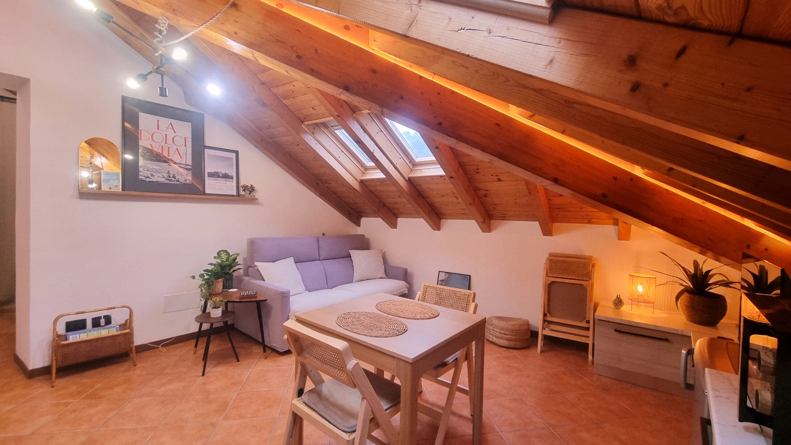 Intérieur cosy sous comble avec poutres et lumière douce