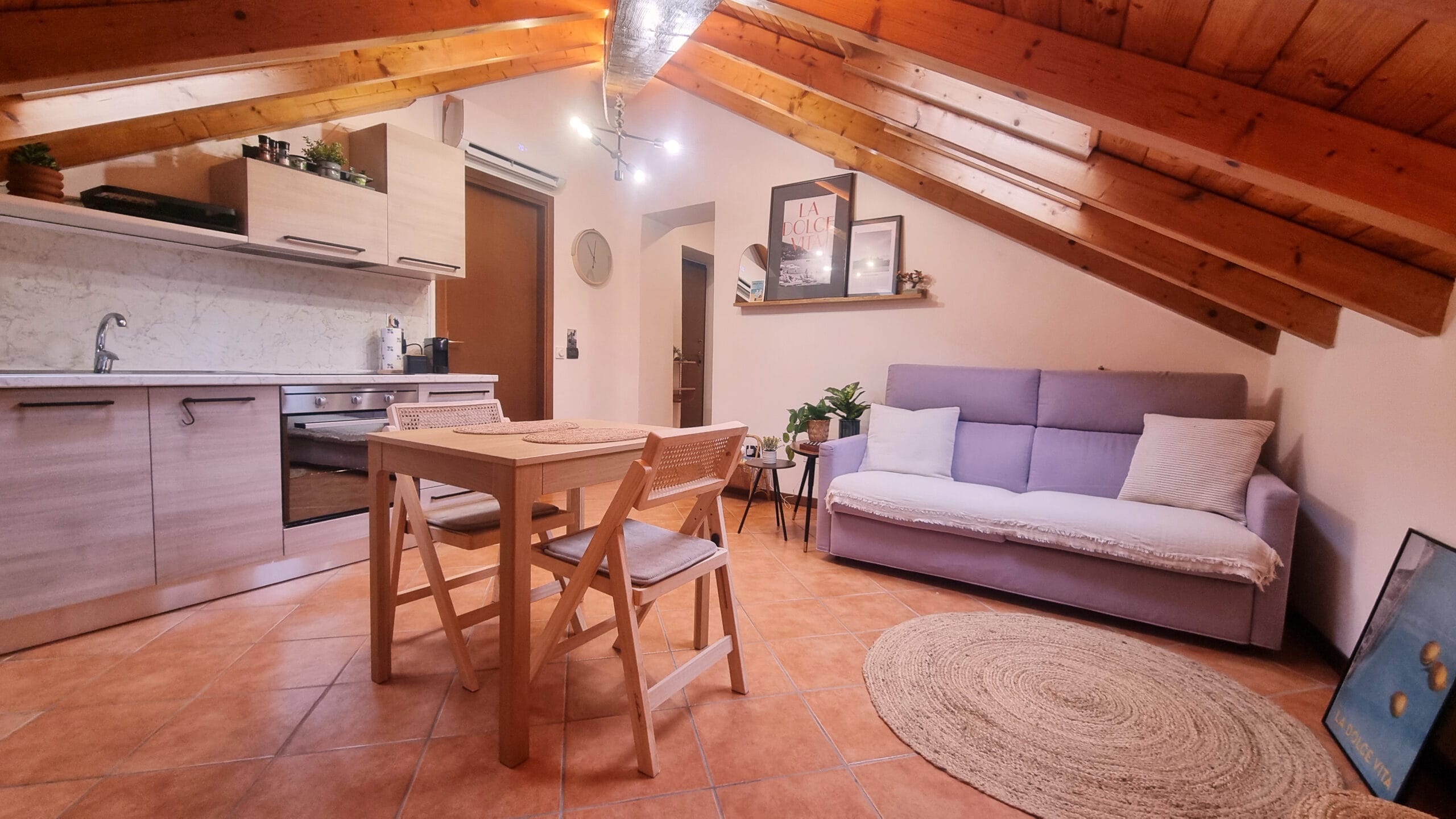 Intérieur cosy avec cuisine ouverte et canapé violet